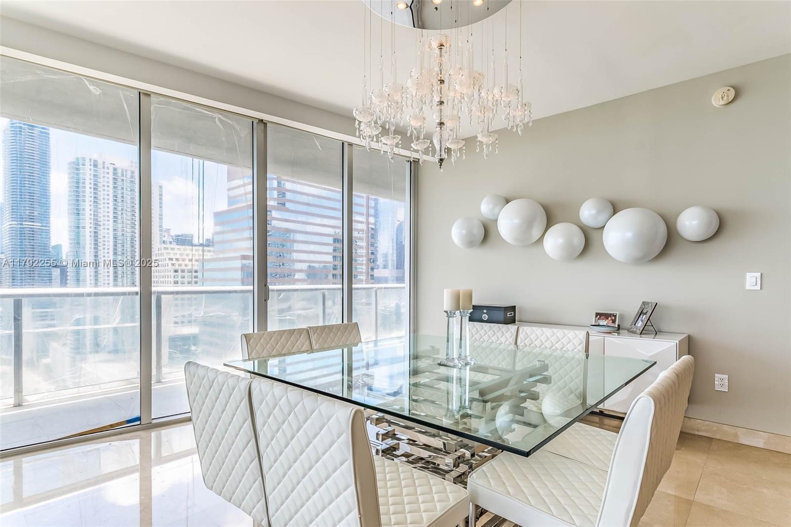 495 Brickell Avenue, Unit 2801 Miami, FL 33131 - Photo 6 of 22 a view of a dining room with furniture a chandelier and large windows