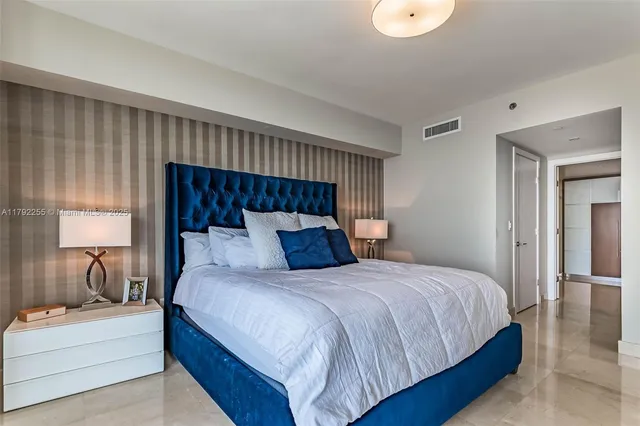 a bedroom with a large bed and a large window