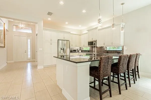 a kitchen with a sink and chairs