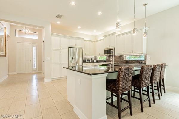 3471 Pacific Drive Naples, FL 34119 - Photo 11 of 29 a kitchen with a sink and chairs