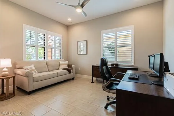 a livingroom with workspace couch and a window