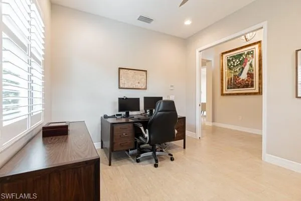 a view of a workspace with furniture and a window
