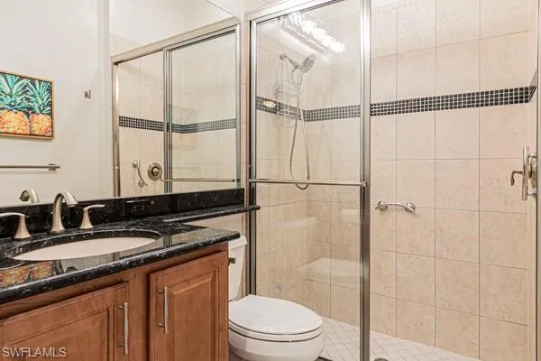 a bathroom with a granite countertop sink toilet and shower