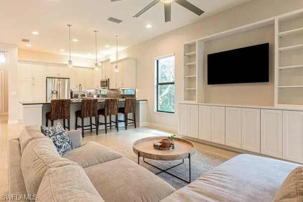 a living room with furniture a flat screen tv and kitchen view