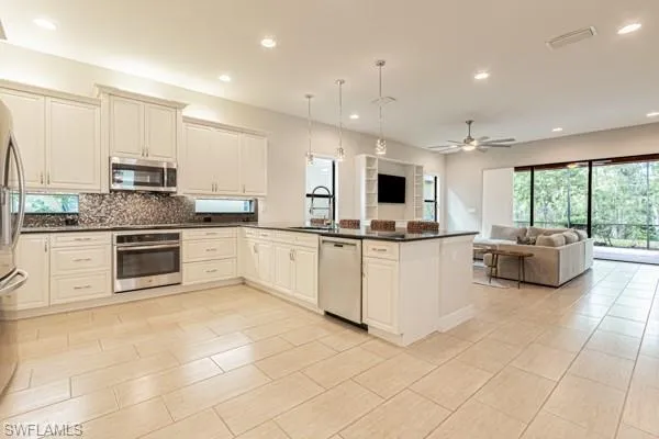 a kitchen with stainless steel appliances kitchen island granite countertop a stove a sink and a microwave