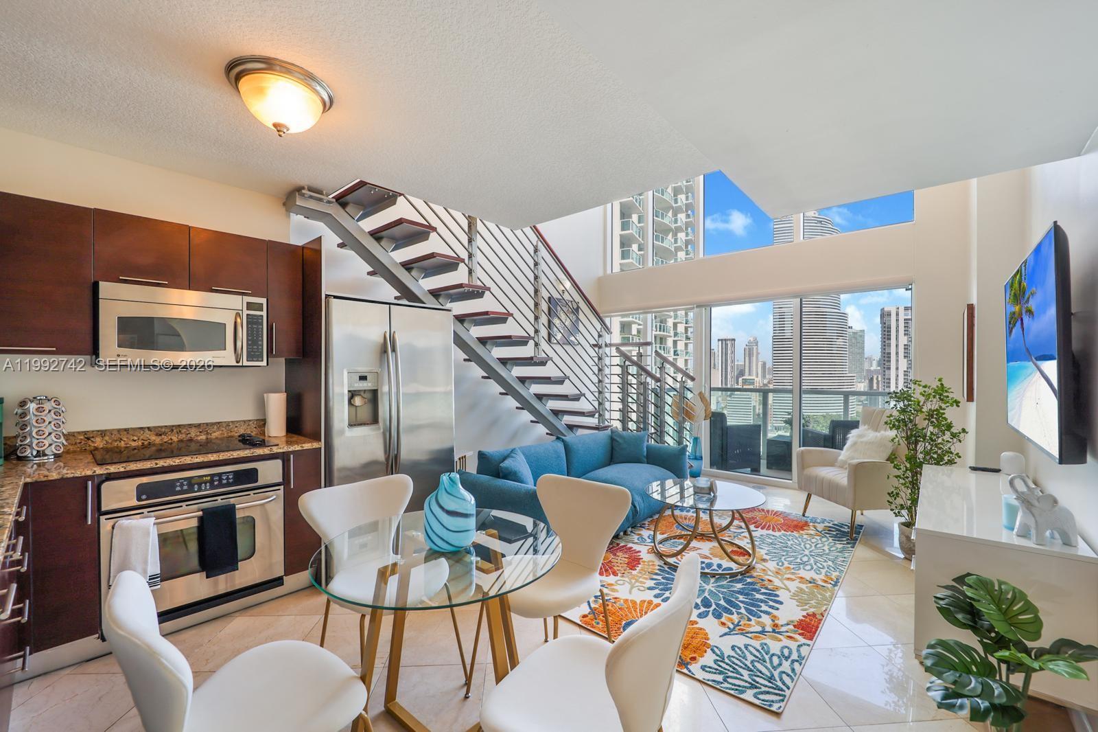 a living room with furniture a rug and a floor to ceiling window