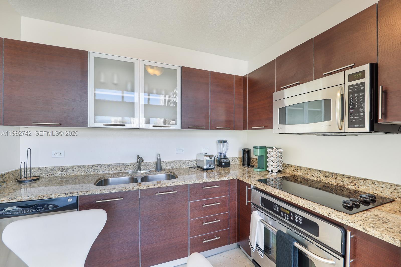 41 Southeast 5th Street, Unit 1505 Miami, FL 33131 - Photo 2 of 16 a kitchen with a sink a stove and cabinets