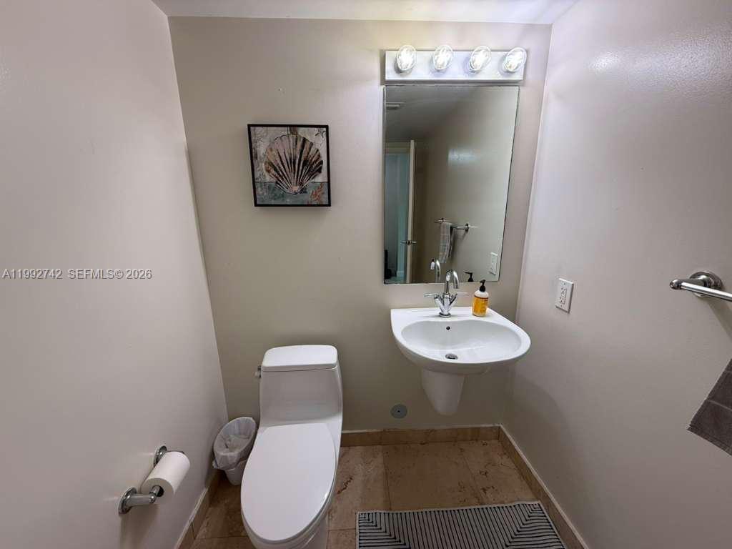41 Southeast 5th Street, Unit 1505 Miami, FL 33131 - Photo 7 of 16 a bathroom with a toilet a sink and mirror