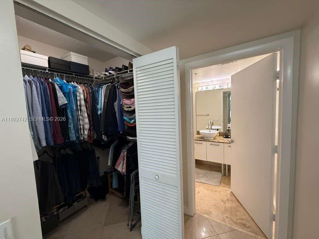41 Southeast 5th Street, Unit 1505 Miami, FL 33131 - Photo 10 of 16 a view of walk in closet with clothes and shoes