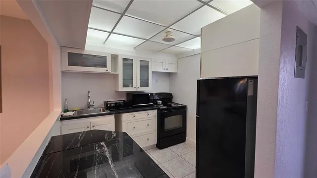a kitchen with granite countertop a refrigerator and a sink
