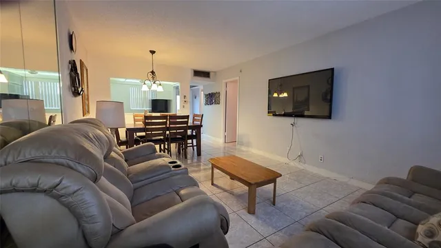 a living room with furniture a flat screen tv and kitchen view