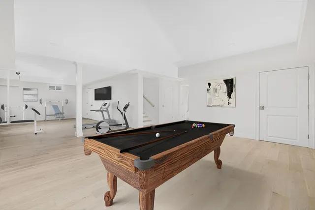 a room with furniture pool table and wooden floor