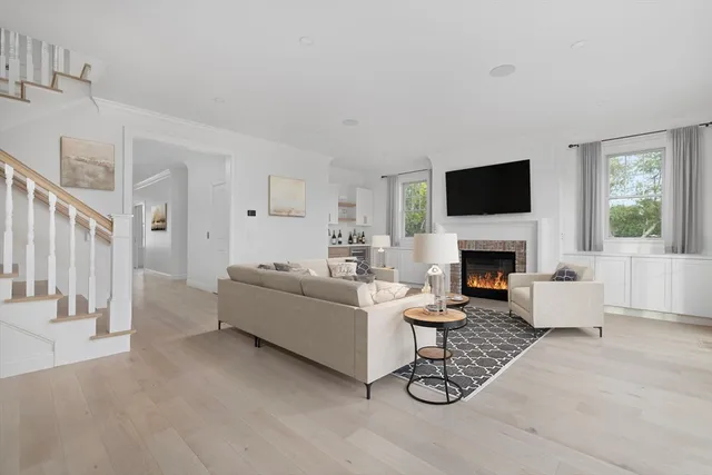 a living room with furniture a fireplace and a flat screen tv