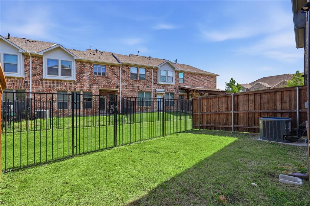 519 Sequoia Street Allen, TX 75002 - Photo 36 of 38 Private backyard featuring a manicured lawn, full wood privacy fencing, and a black wrought iron style fence
