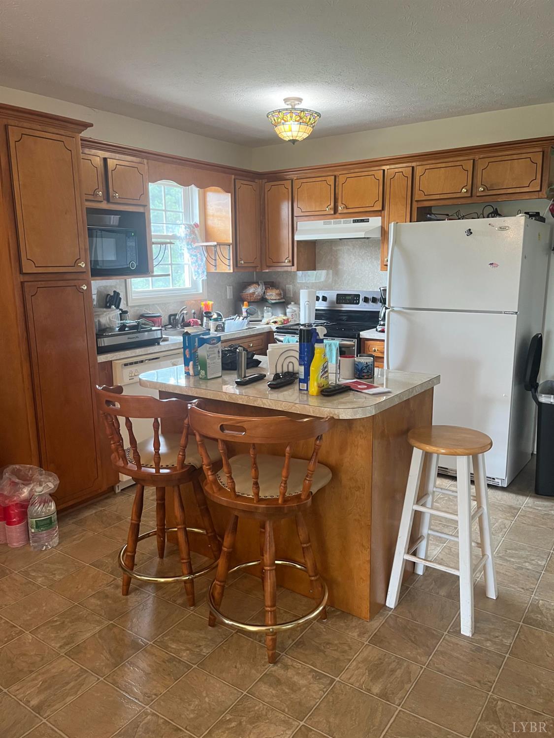 2135 Spring Garden Road Chatham, VA 24531 - Photo 3 of 18 a kitchen with a table chairs refrigerator and microwave
