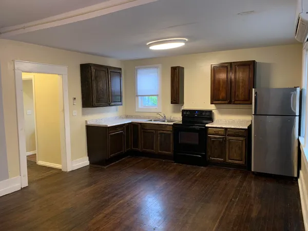 a kitchen with a refrigerator and a stove top oven