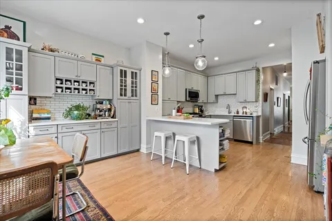 a kitchen with white cabinets and stainless steel appliances