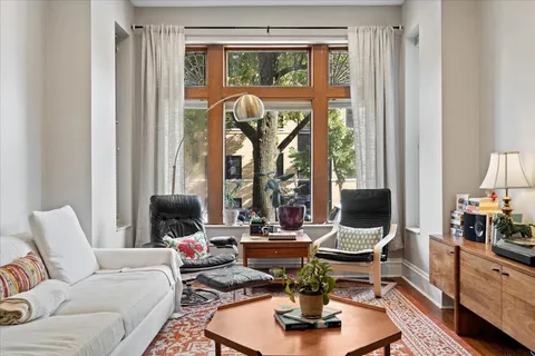 a living room with furniture fireplace and a large window