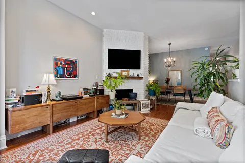 a living room with furniture kitchen view and a flat screen tv