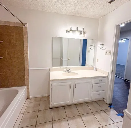 a spacious bathroom with a bathtub sink and a mirror