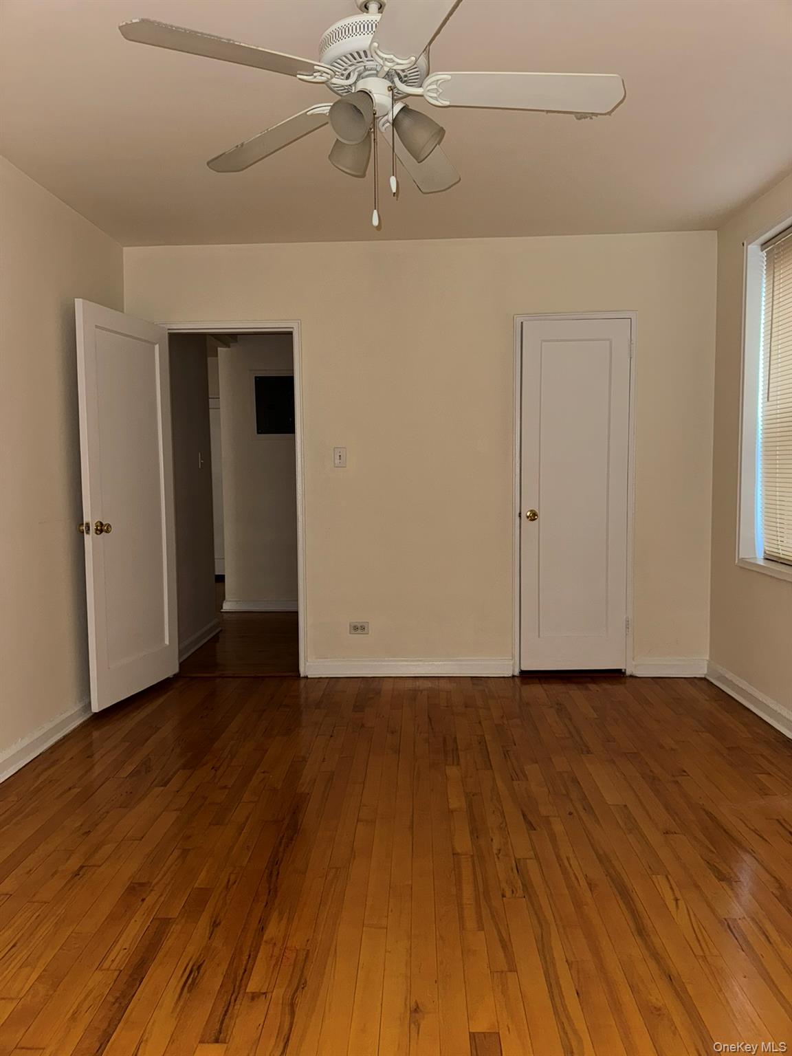 88-10 34th Avenue, Unit 2M Queens, NY 11372 - Photo 11 of 12 wooden floor in an empty room with a window