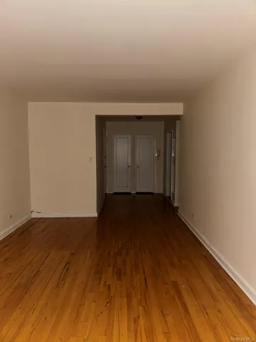 a view of an empty room and wooden floor