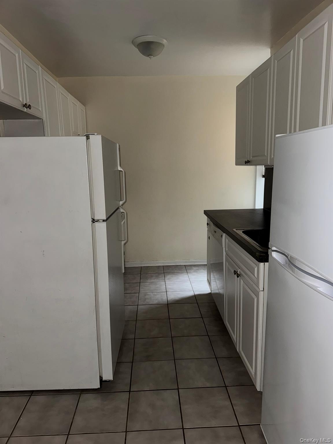 88-10 34th Avenue, Unit 2M Queens, NY 11372 - Photo 7 of 12 a kitchen with a refrigerator and a cabinets