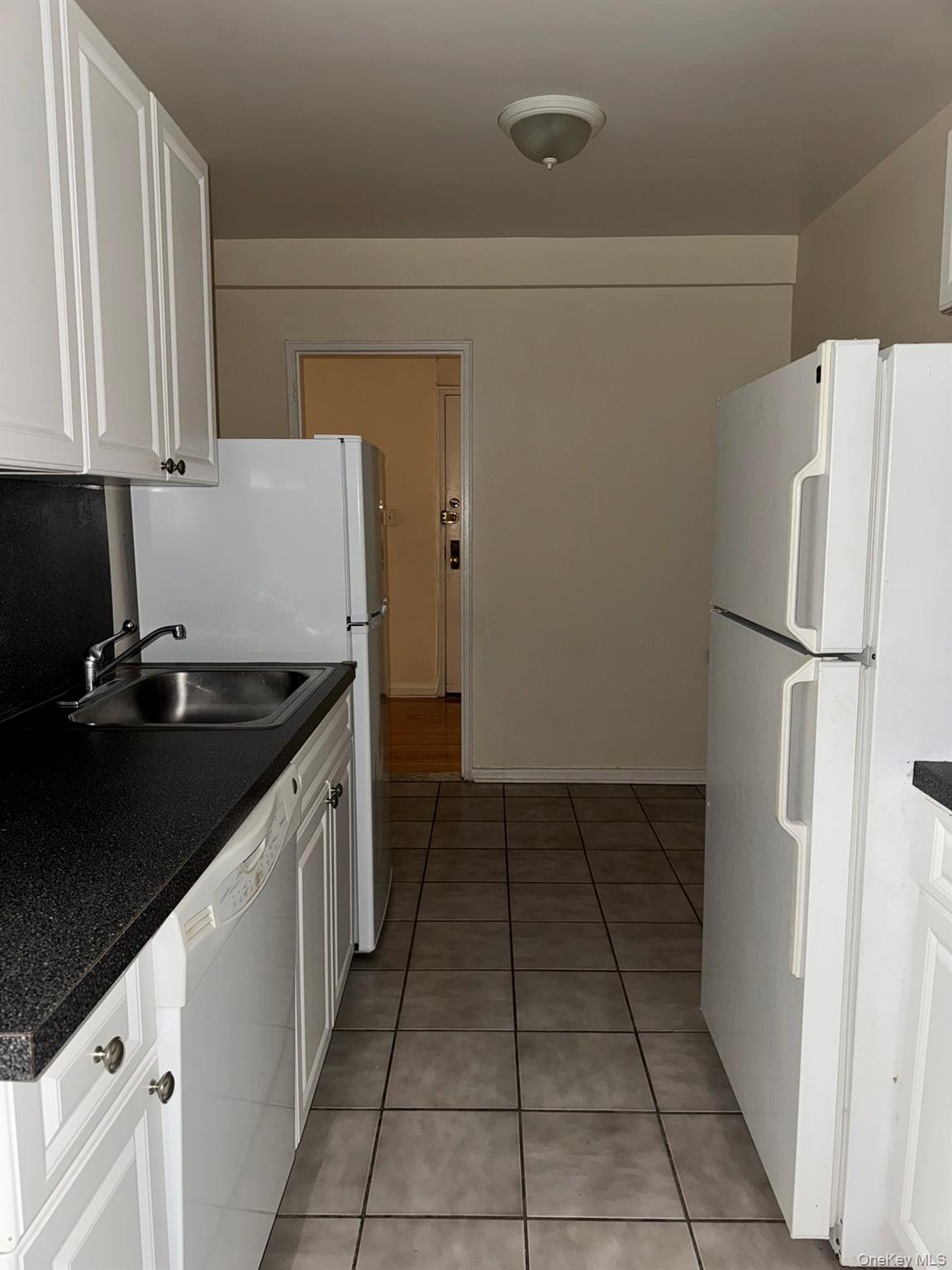 88-10 34th Avenue, Unit 2M Queens, NY 11372 - Photo 8 of 12 a kitchen with a sink a refrigerator and cabinets