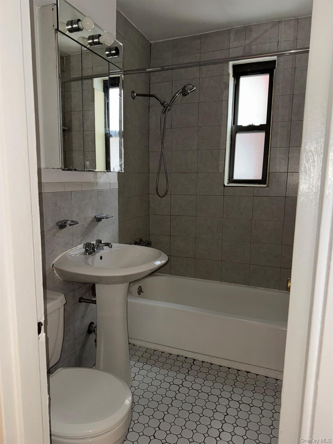 88-10 34th Avenue, Unit 2M Queens, NY 11372 - Photo 9 of 12 a bathroom with a sink a toilet and shower