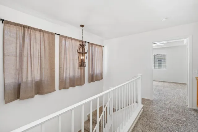 an empty room with ceiling fan and windows