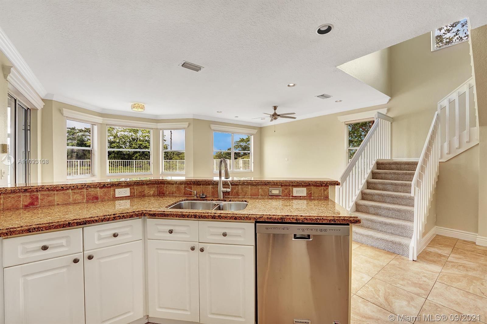 18672 Sea Turtle Lane Boca Raton, FL 33498 - Photo 9 of 44 a kitchen with granite countertop a sink and white cabinets