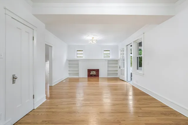 a view of a livingroom with wooden floor and a fireplace