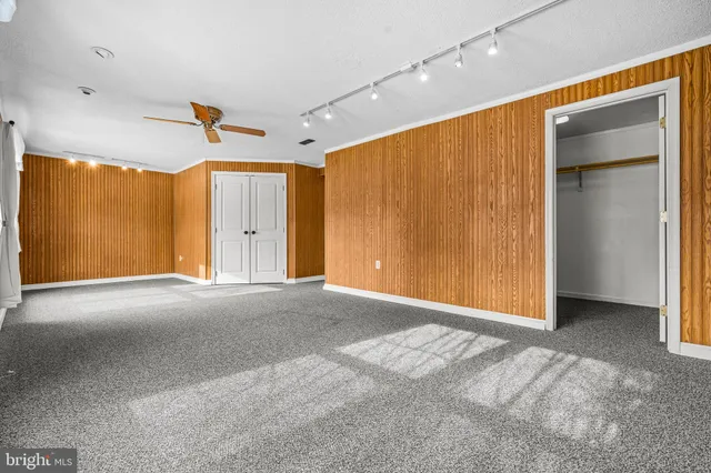 an empty room with a ceiling fan and entryway