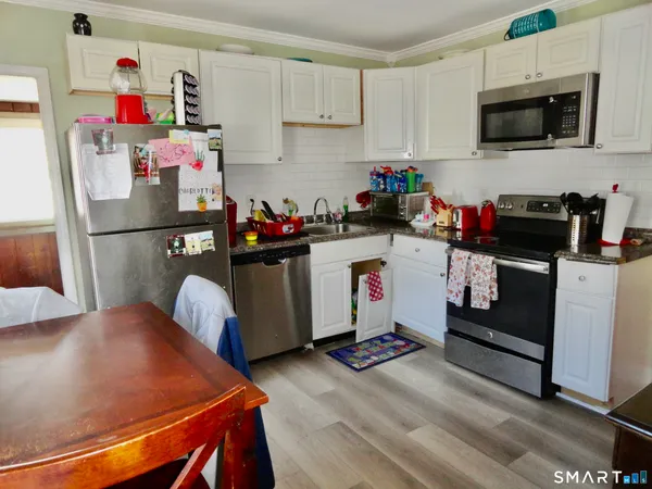 a kitchen with a refrigerator and a stove top oven