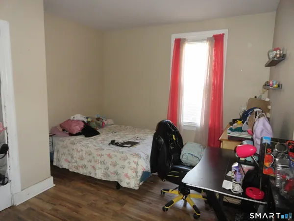 a bedroom with a bed and wooden floor