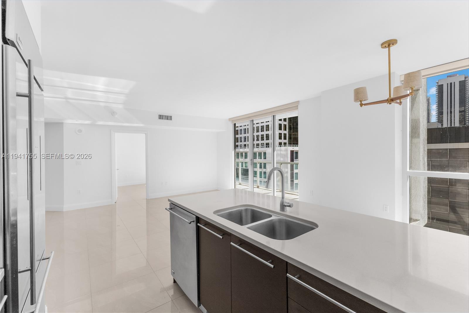 55 Southeast 6th Street, Unit 1202 Miami, FL 33131 - Photo 13 of 45 a kitchen with a sink and white cabinets