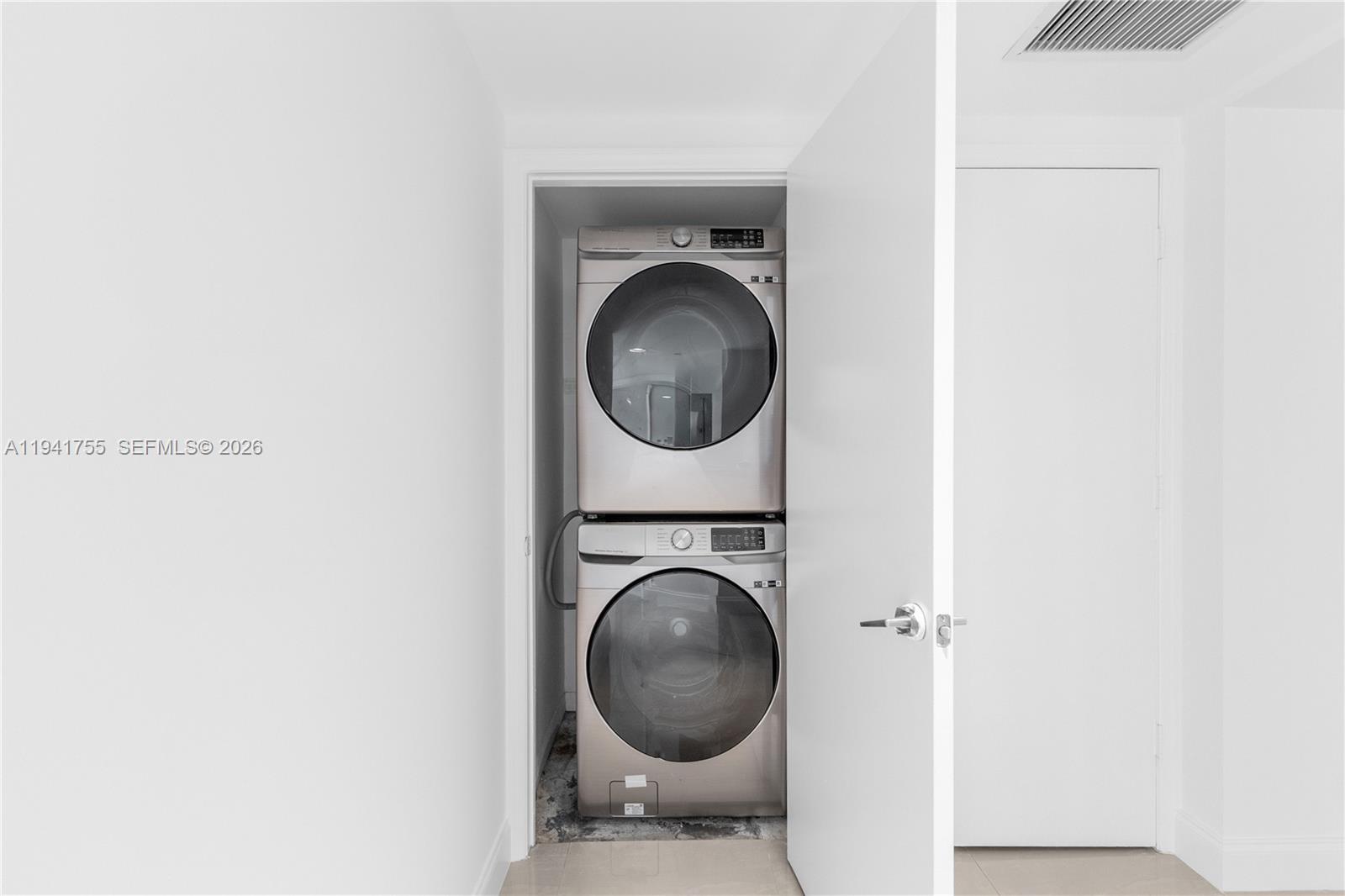 55 Southeast 6th Street, Unit 1202 Miami, FL 33131 - Photo 14 of 45 a view of a bedroom with washer and dryer