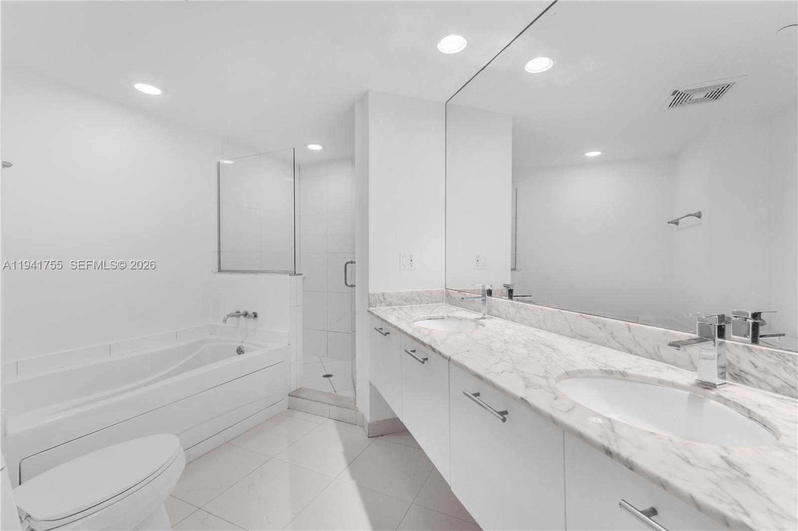 55 Southeast 6th Street, Unit 1202 Miami, FL 33131 - Photo 19 of 45 a bathroom with a granite countertop sink mirror and bathtub