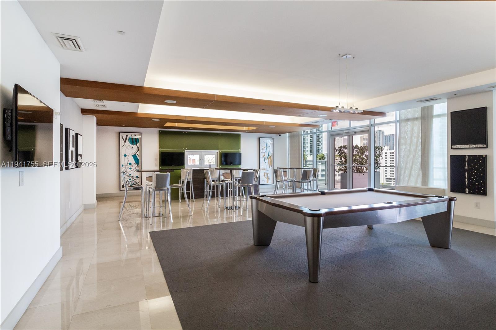 55 Southeast 6th Street, Unit 1202 Miami, FL 33131 - Photo 35 of 45 a dining hall with couches a flat tv screen and a dining table with garden view