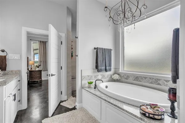 a bathroom with a tub a sink and a mirror