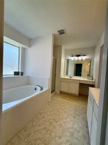 a bathroom with a tub sink and mirror
