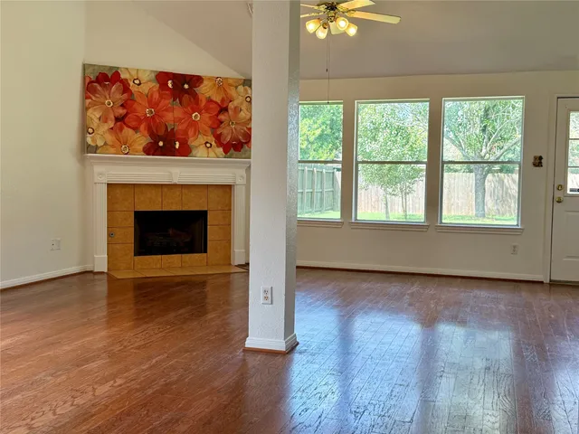 wooden floor fireplace and windows in an empty room