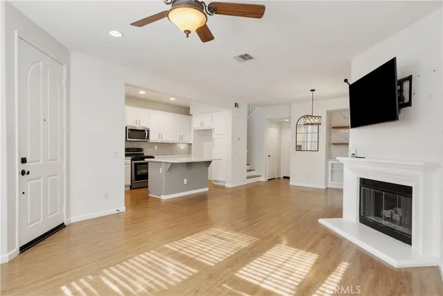a view of kitchen living room with microwave and fireplace
