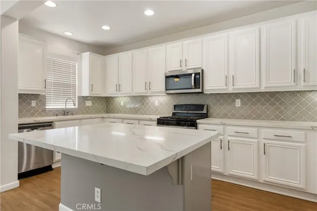 a kitchen with appliances a sink and cabinets