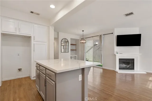 a open kitchen with a sink and a stove top oven with wooden floor