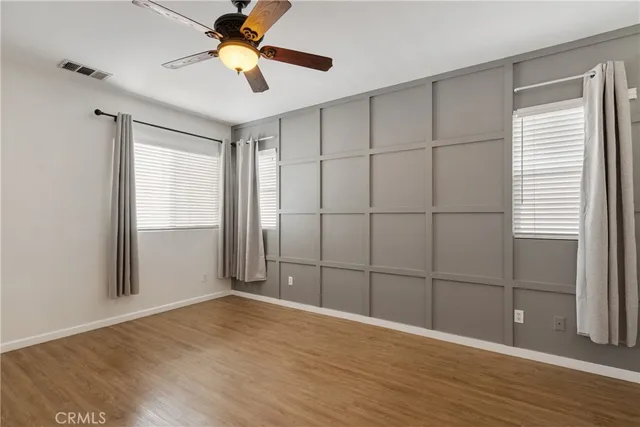 a view of a room with wooden floor and ceiling fan