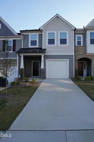 a front view of a house with a garden and garage