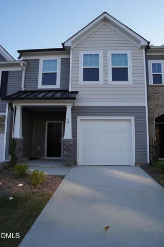 a front view of a house with yard and parking space
