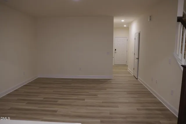 a view of a room with wooden floor and white walls