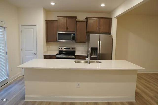 a kitchen with stainless steel appliances a refrigerator sink stove microwave and cabinets